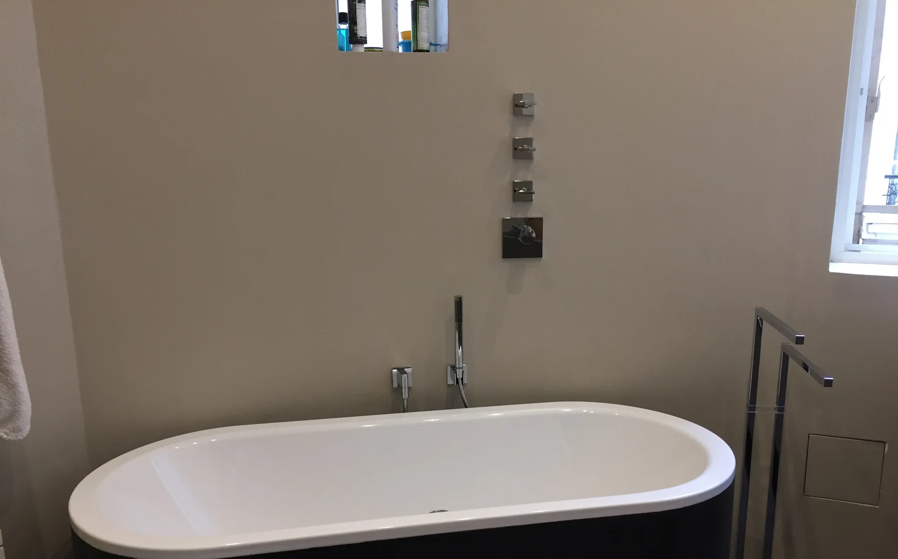 Modern bathtub with anthracite panel and chrome fittings